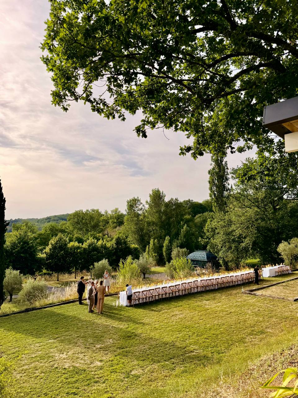 Wedding banquet table set on the lawn overlooking the valley at Les Cazettes, a wedding venue in the Tarn